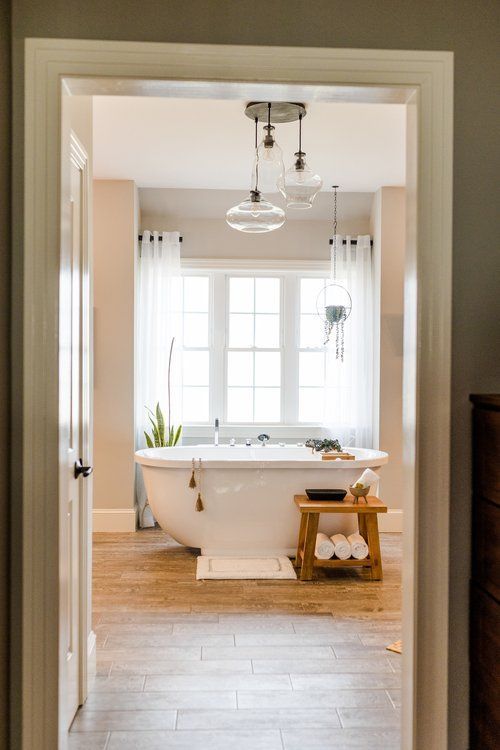 A bathroom with a tub and a window.