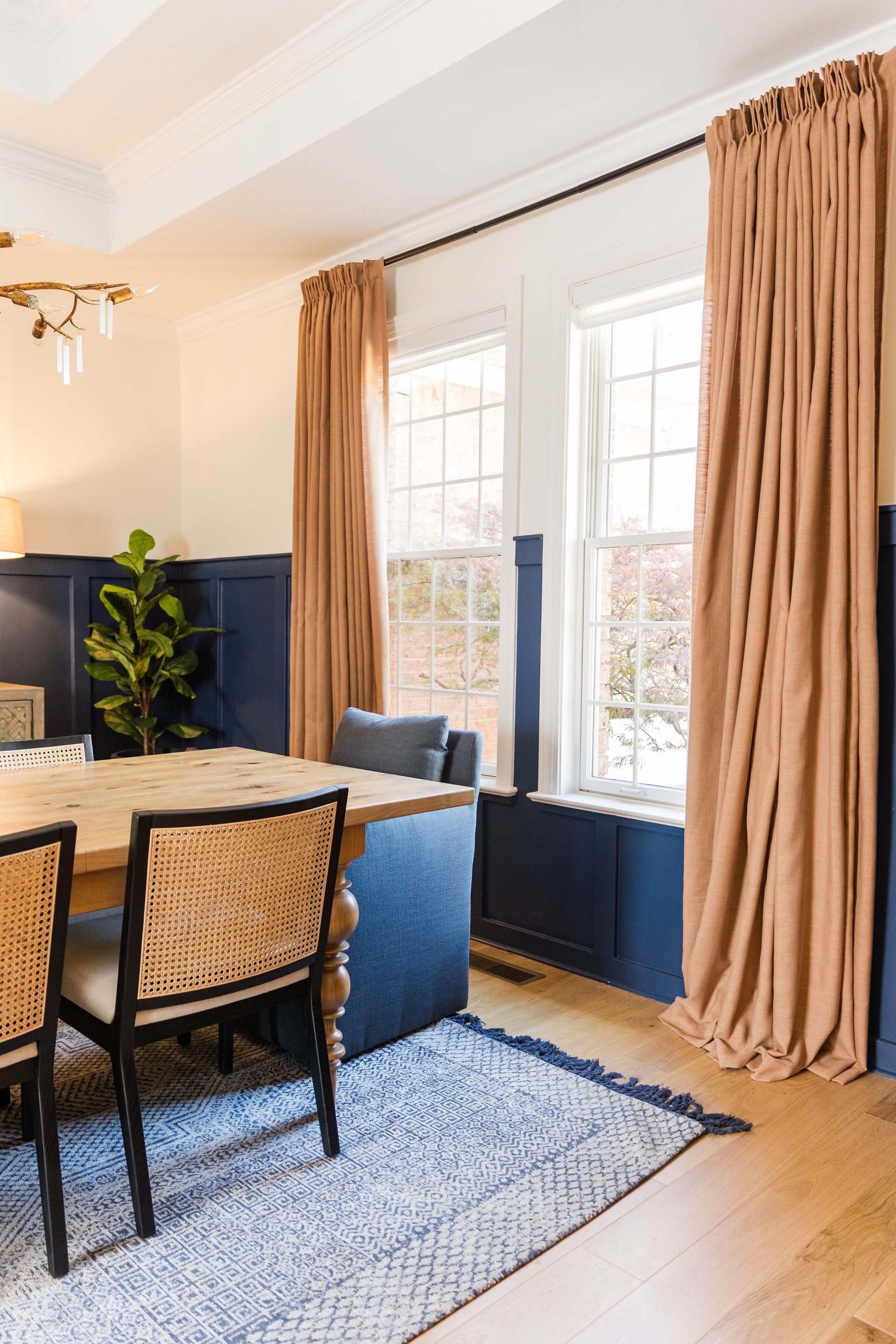 A dining room with a table and chairs and a rug.