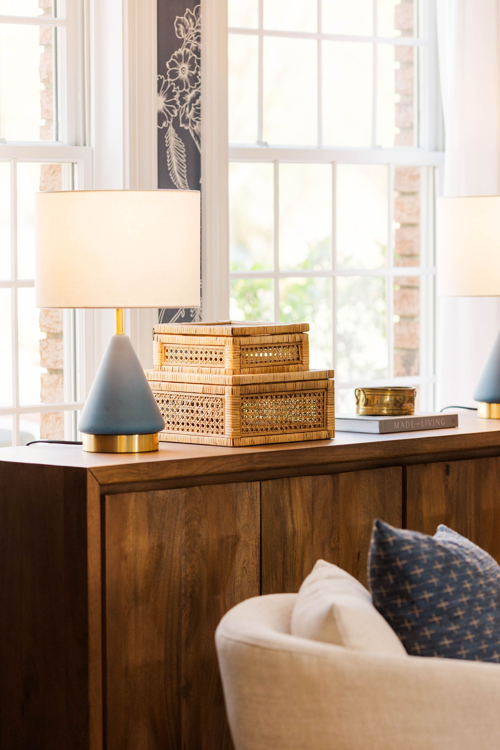 A living room with two lamps on a wooden dresser.