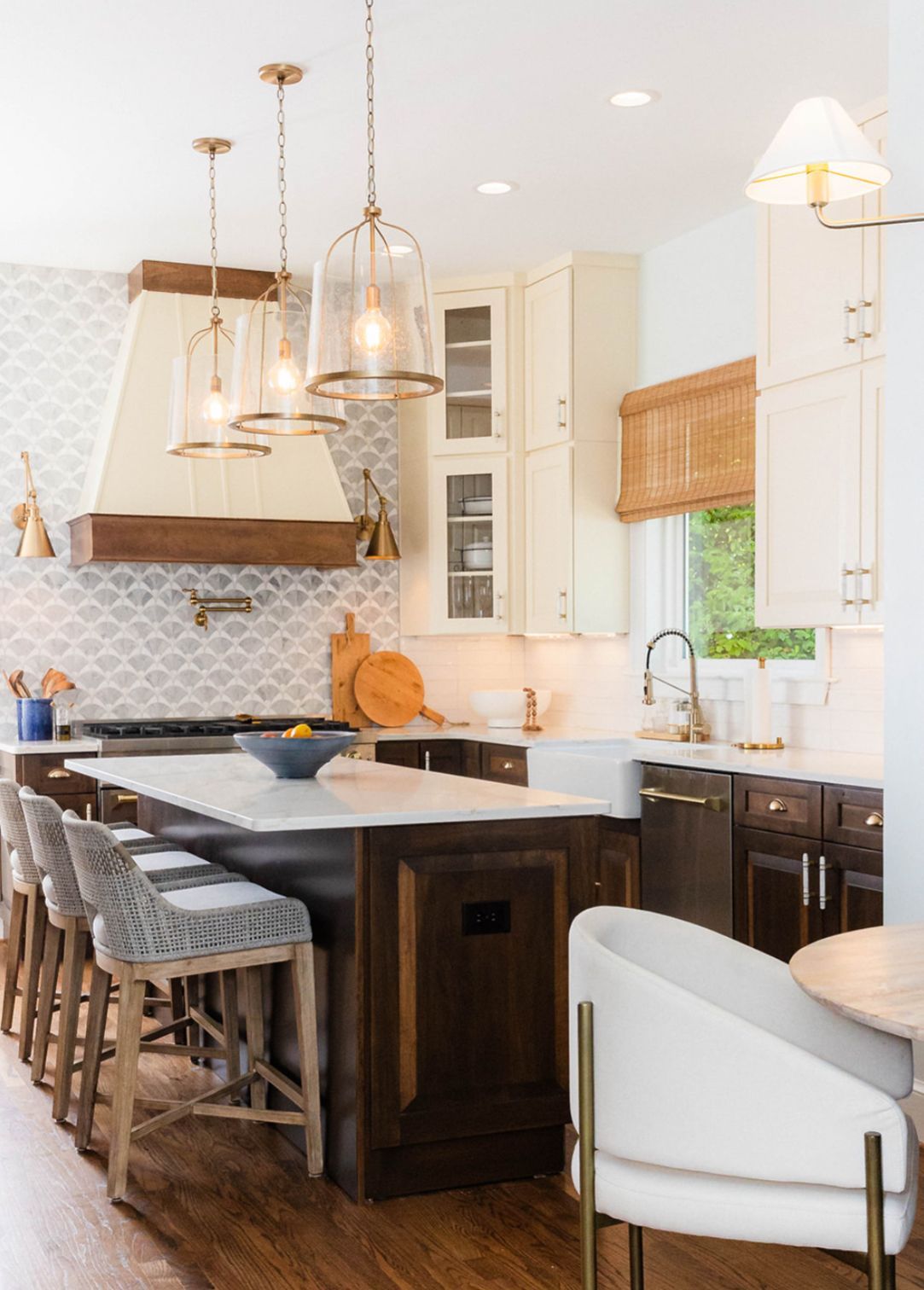 A kitchen with a large island , chairs , stools and a sink.