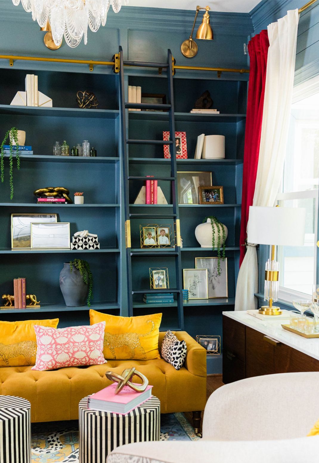 A living room with a yellow couch and blue shelves.