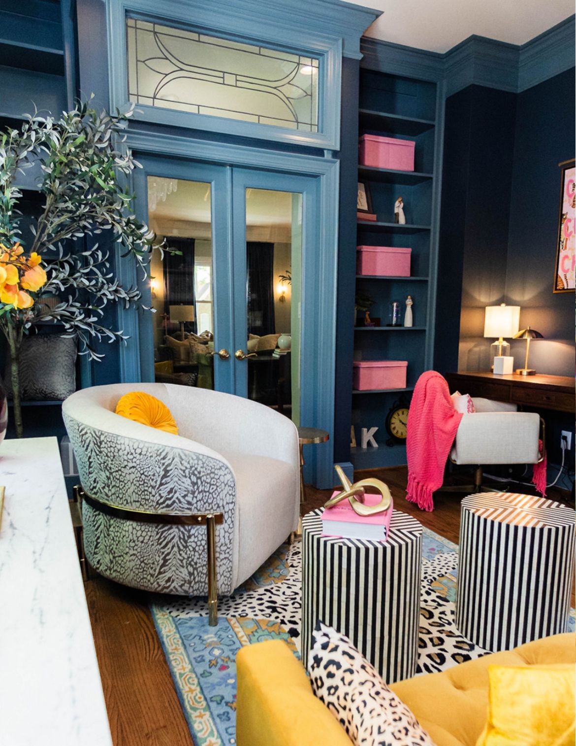 A living room with a yellow couch and a white chair