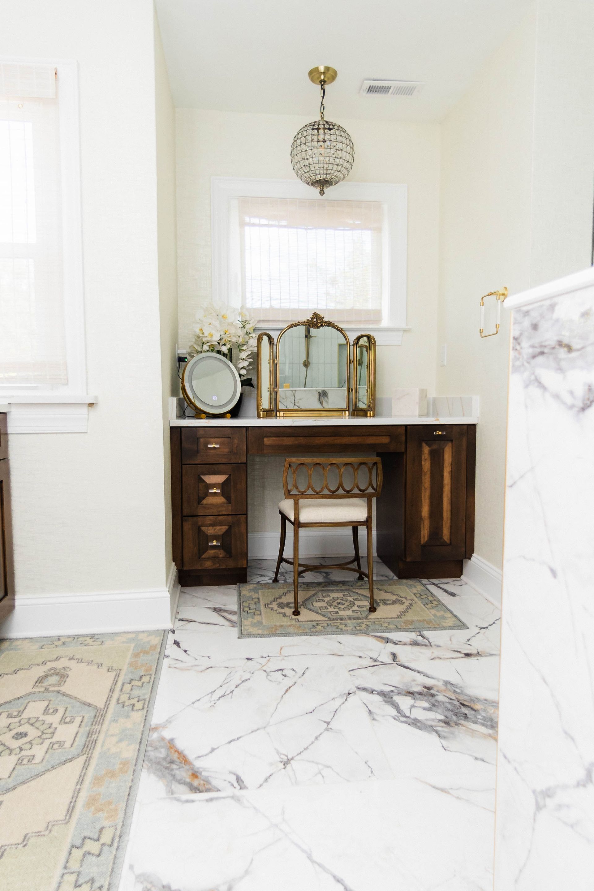 A vanity mirror and a chair in the bathroom.
