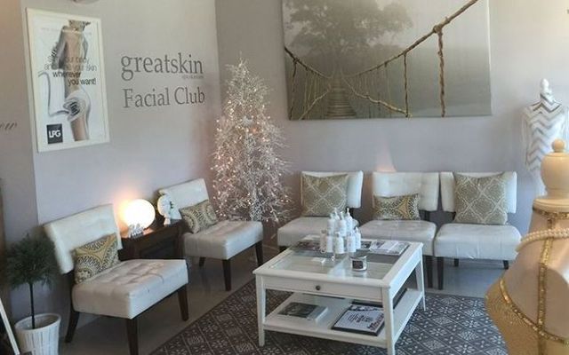 A waiting room with chairs , a coffee table and a christmas tree.