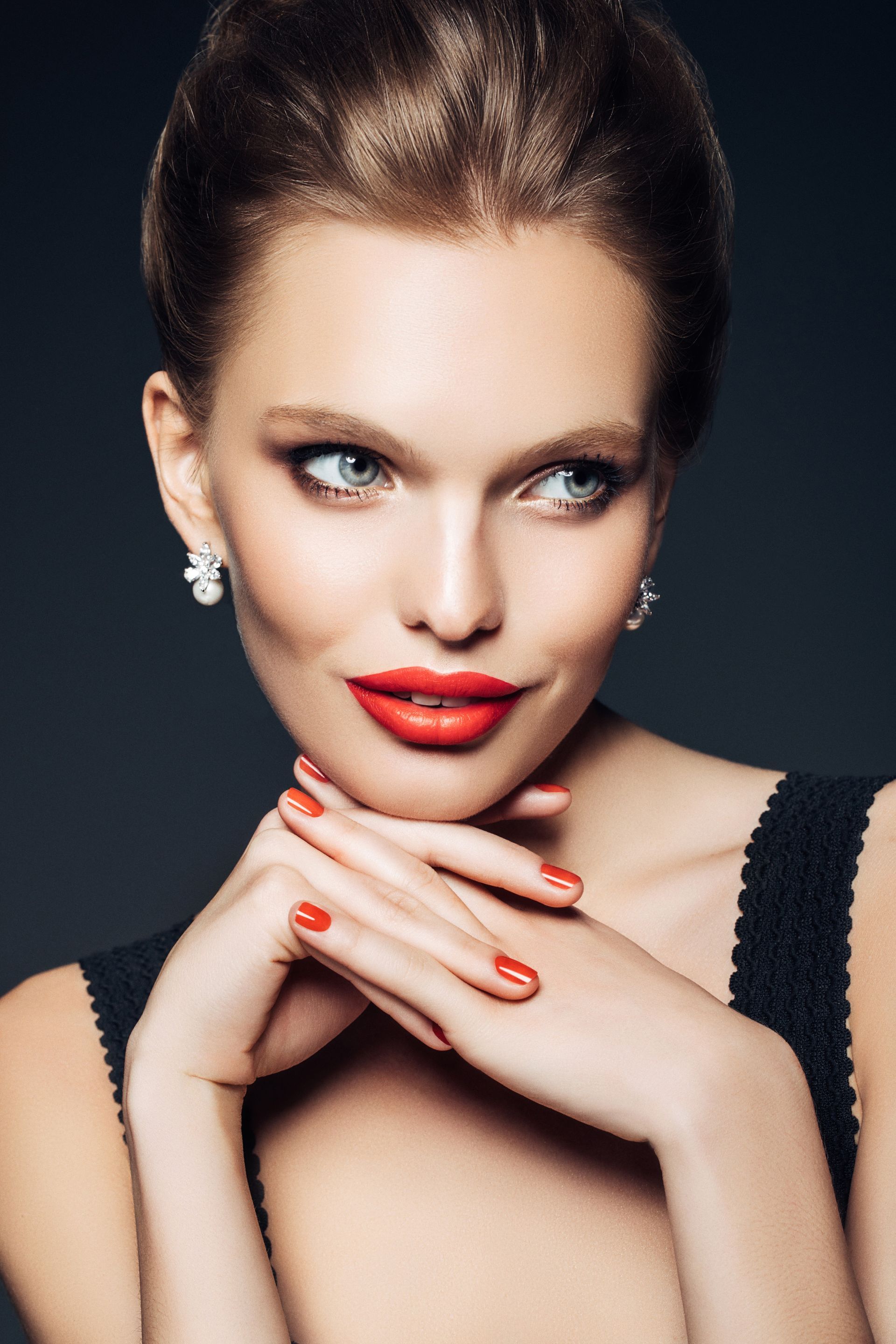 The woman is wearing red lipstick and red nails.