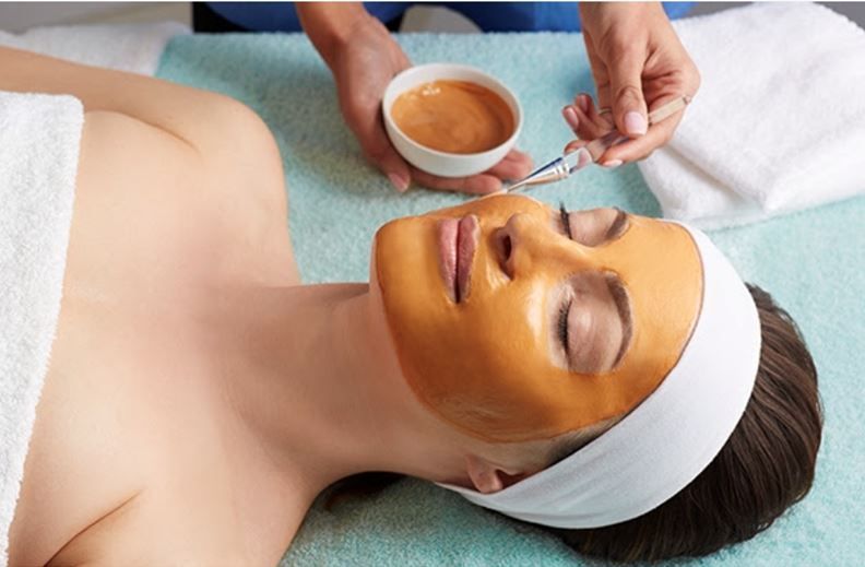 A woman is getting a facial treatment at a spa.