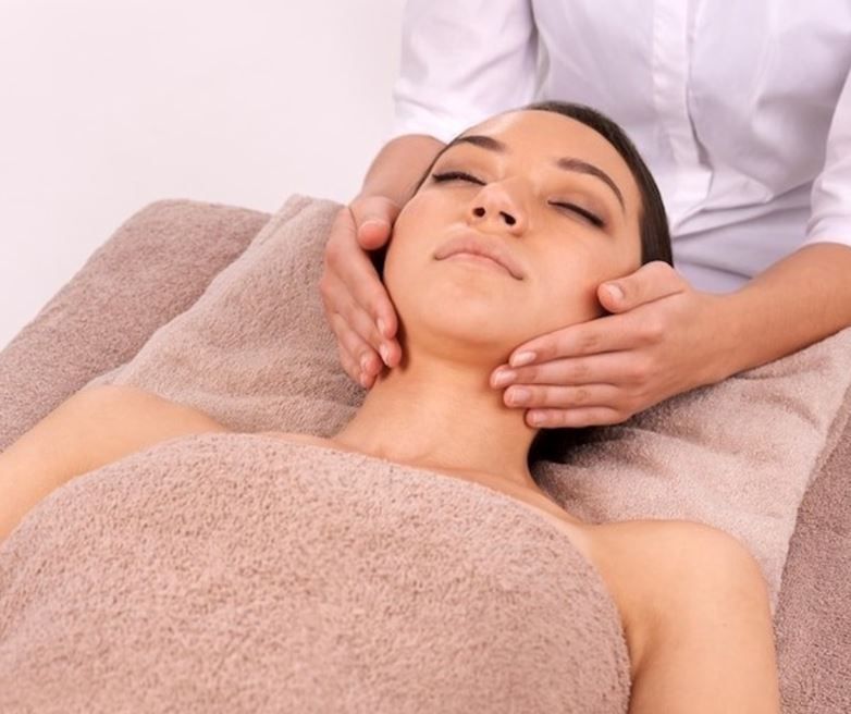 A woman wrapped in a towel is getting a massage