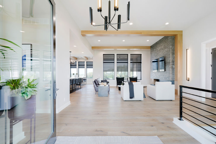 Modern living room with light wood floors, white walls, and contemporary furniture.