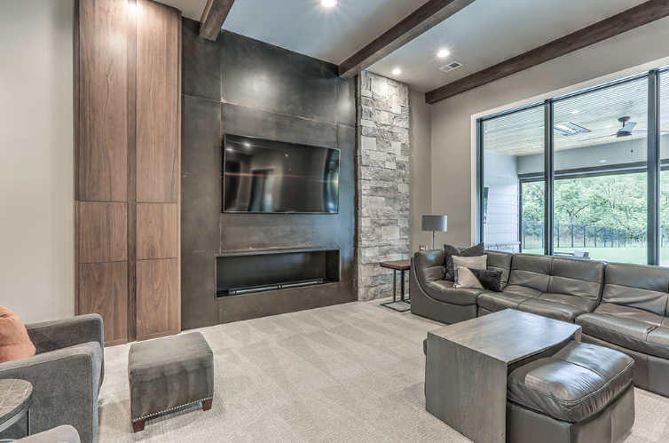 Living room with gray sectional sofa, fireplace, and large window.