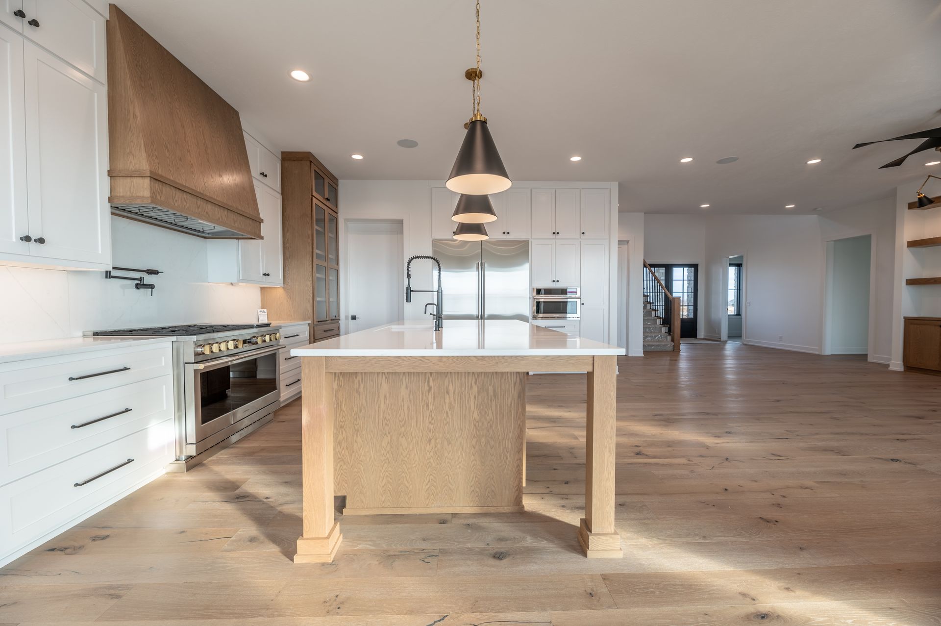 Modern kitchen with white cabinets, wood accents, and an island.
