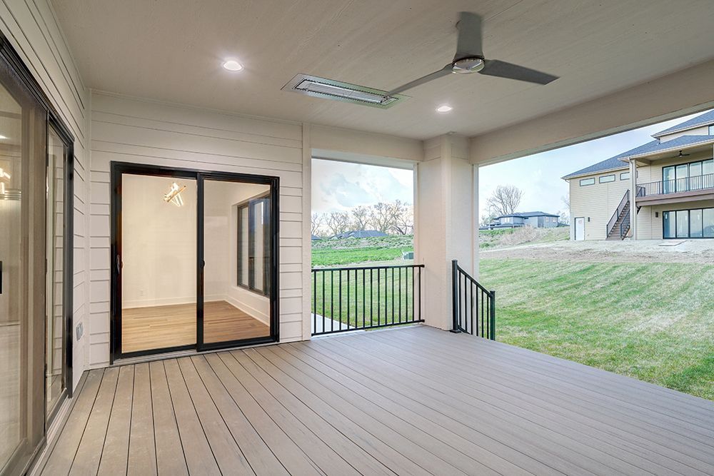 Covered back patio with a composite deck, ceiling fan, and sliding glass doors.