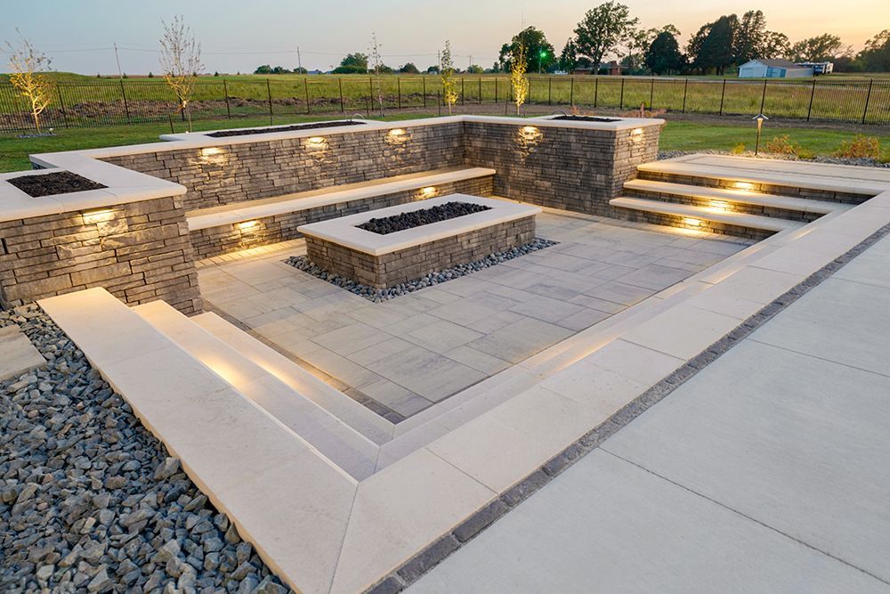 Outdoor patio with built-in seating, stone fire pit, and step lighting.