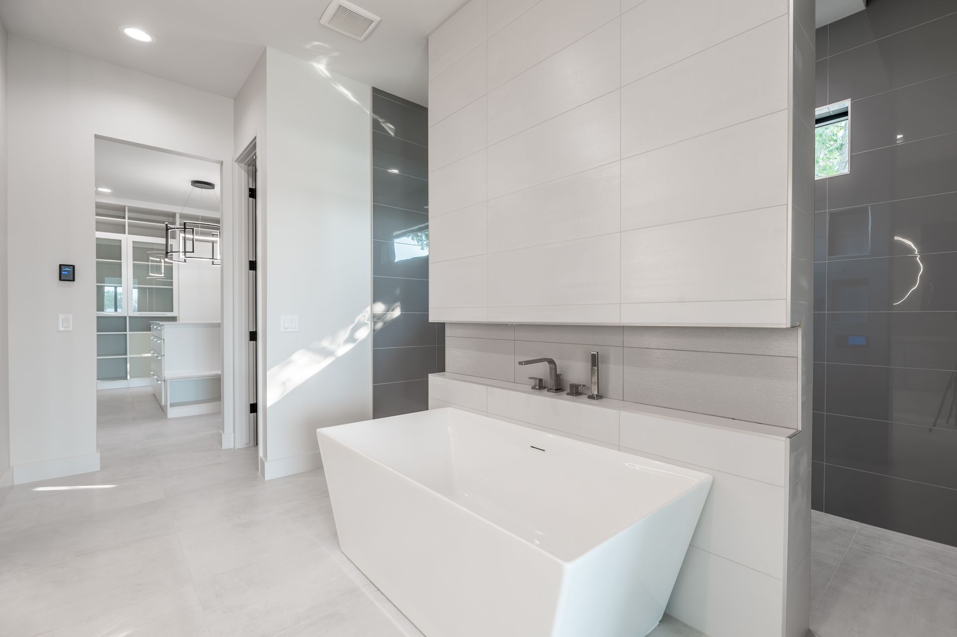 Modern bathroom with white tub, tiled walls, and walk-in shower.