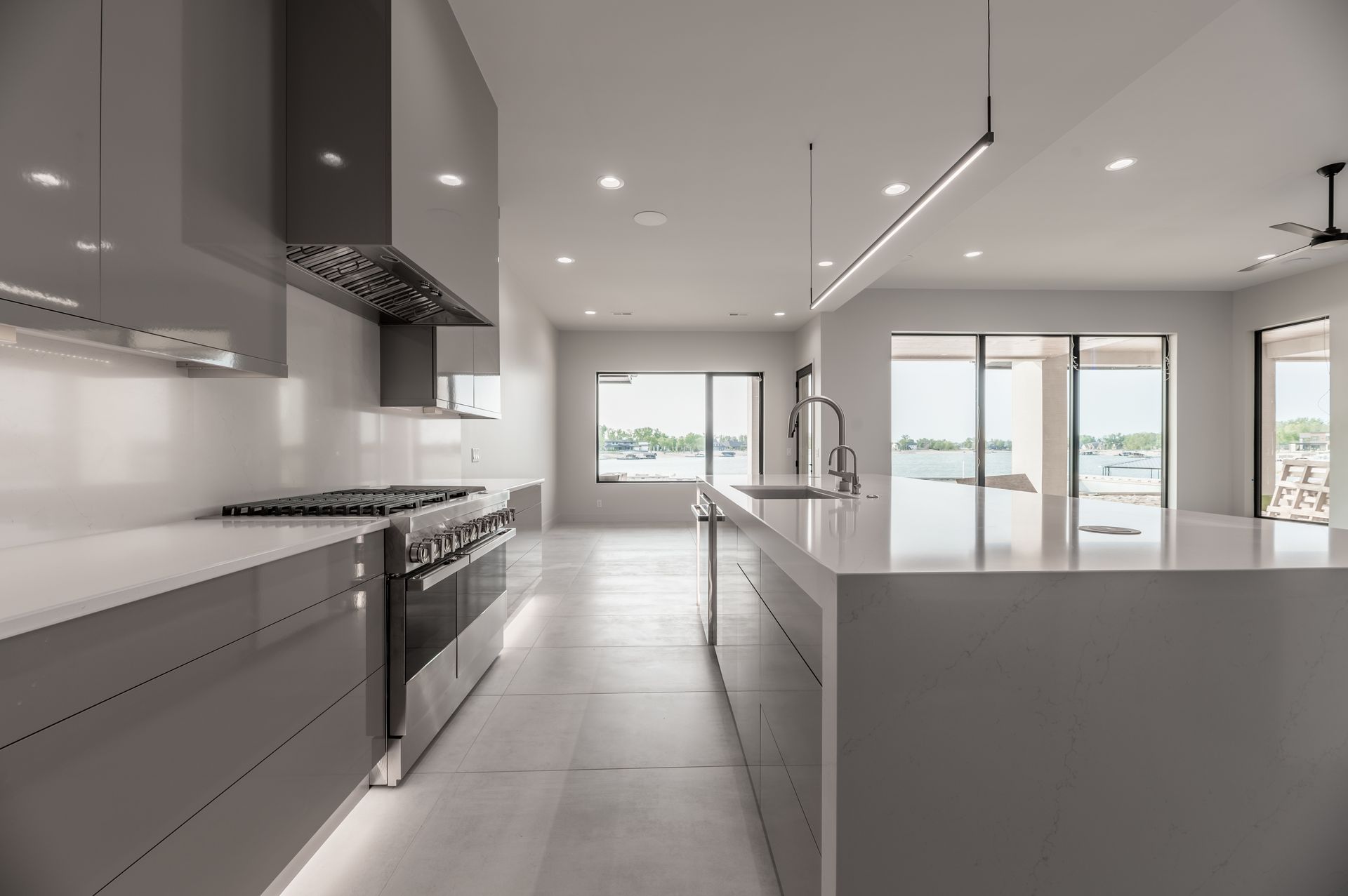 Modern kitchen with grey cabinets, white countertops, and stainless steel appliances.