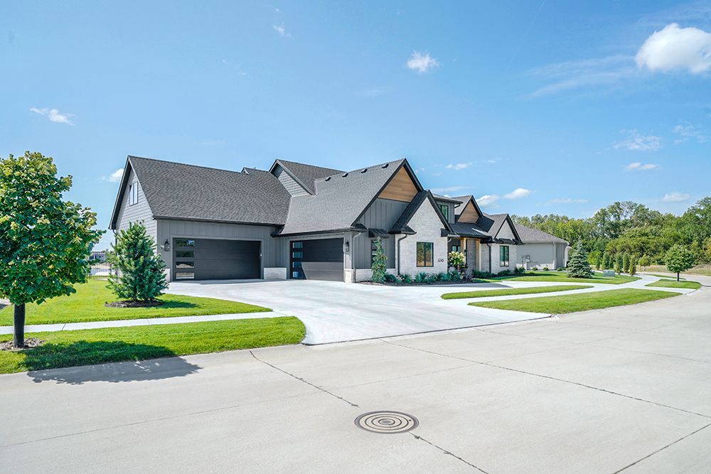 Modern, gray and white house with a two-car garage, on a sunny day.