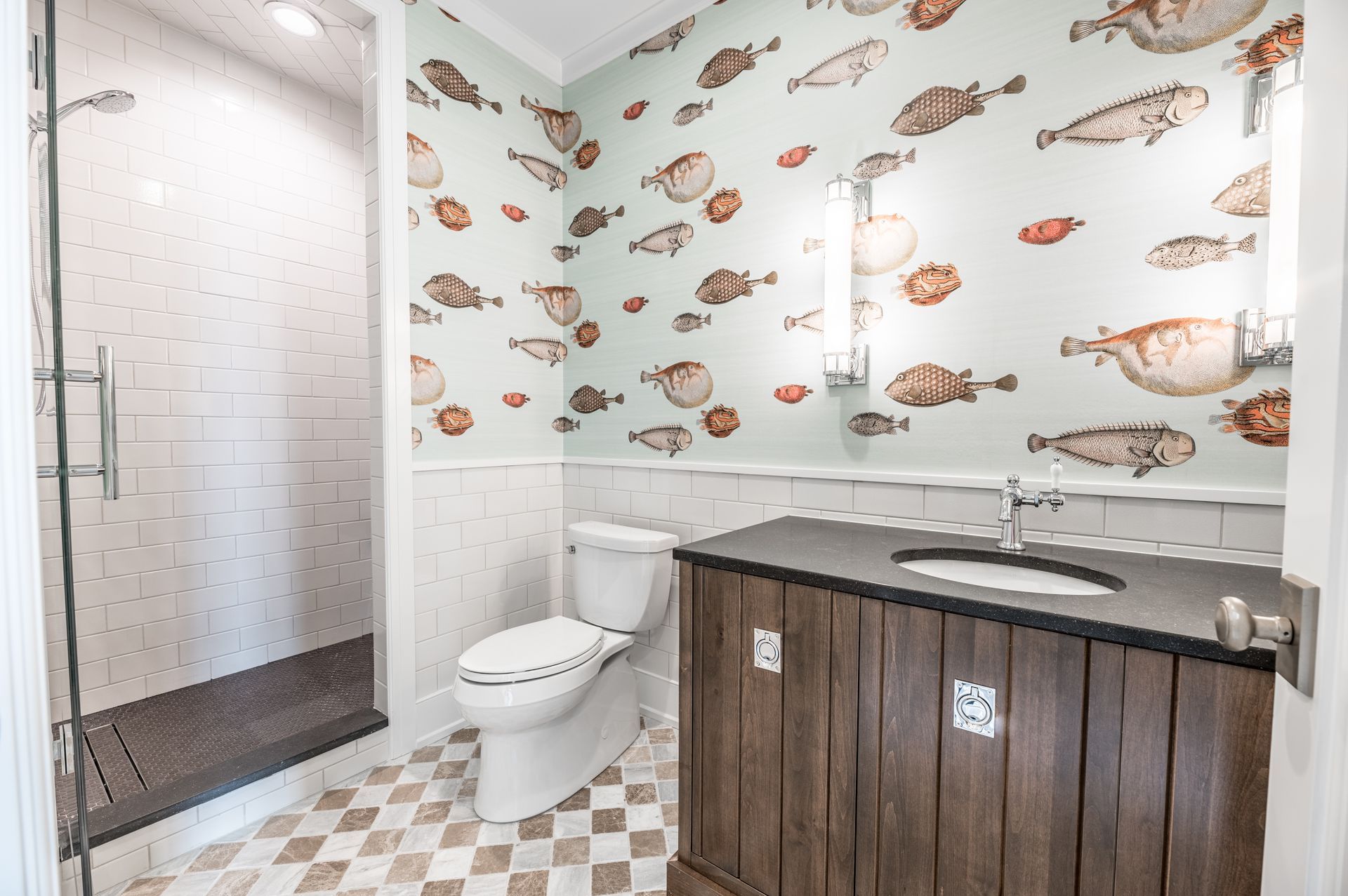 Bathroom with fish wallpaper, shower, toilet, and wooden vanity.