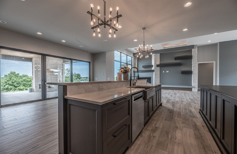 Modern kitchen with gray cabinets, island, and large windows.