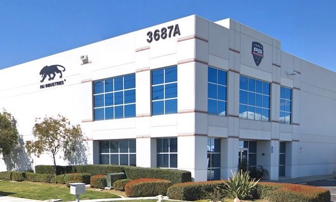 White building with blue windows, address 3687A, company logos, landscaping, and clear blue sky.