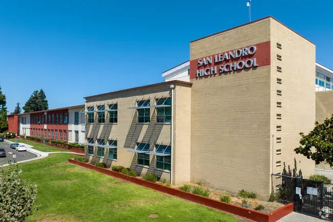 San Leandro High School exterior, beige and red brick building, sunny day.