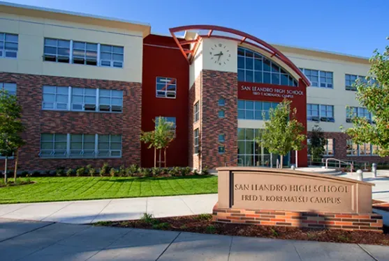San Leandro High School building with red brick and clock tower on a sunny day.