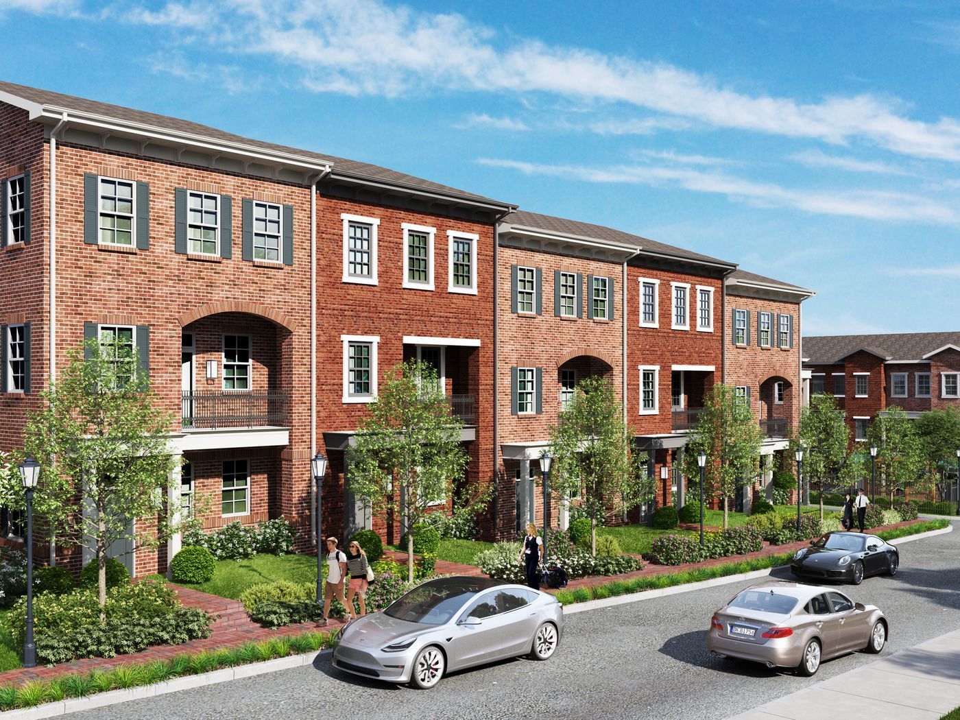 Row of brick townhouses with parked cars on street. Trees and landscaping in front.