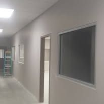 Hallway with white walls, open door, and a window.