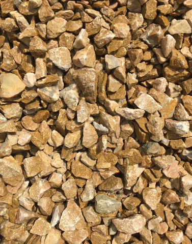 Pile of golden-brown gravel rocks, varying in size and shape, textured surface.