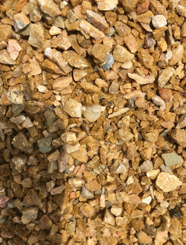 Close-up view of tan and beige crushed gravel, showing various rock sizes and colors.