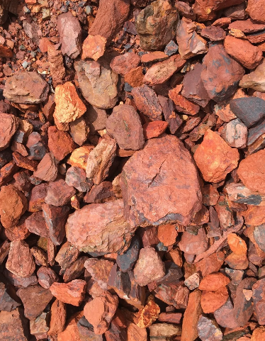 Reddish-brown rocks and stones scattered together, varying in size and shape.