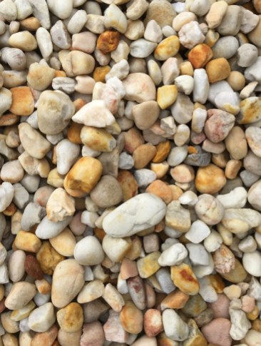 Pile of smooth, rounded beige, tan, and orange river rocks.