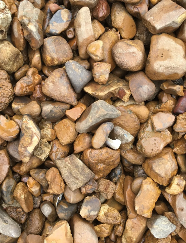 Brown and tan river rocks, various sizes, filling the frame.