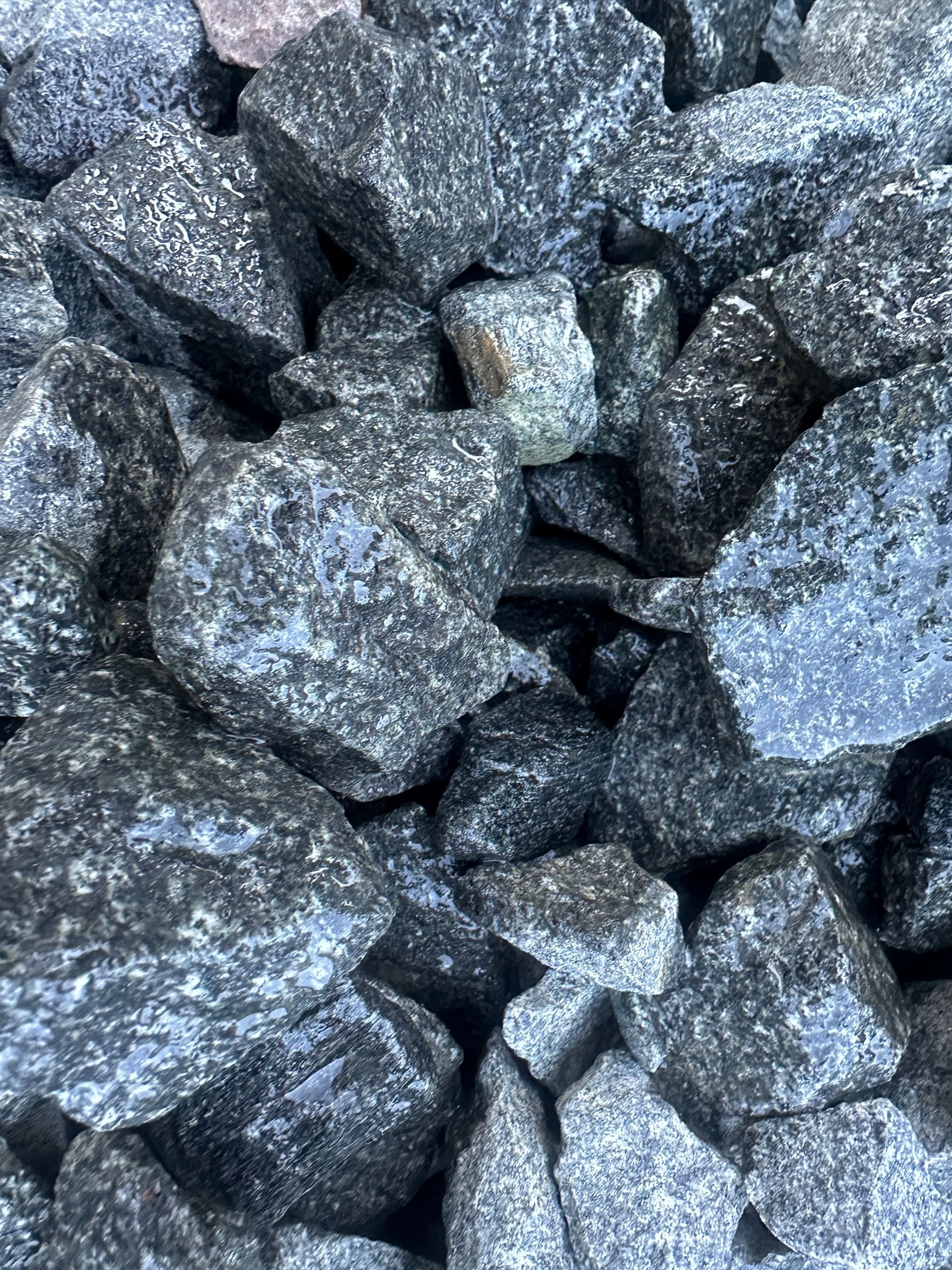 Pile of dark, gray and blue rocks with rough surfaces.