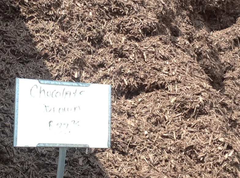 Chocolate brown mulch pile with a sign that reads