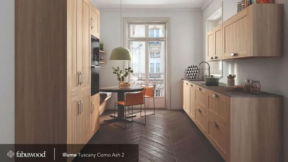 Modern kitchen with light wood cabinets, dark wood floor, and small round table with chairs.