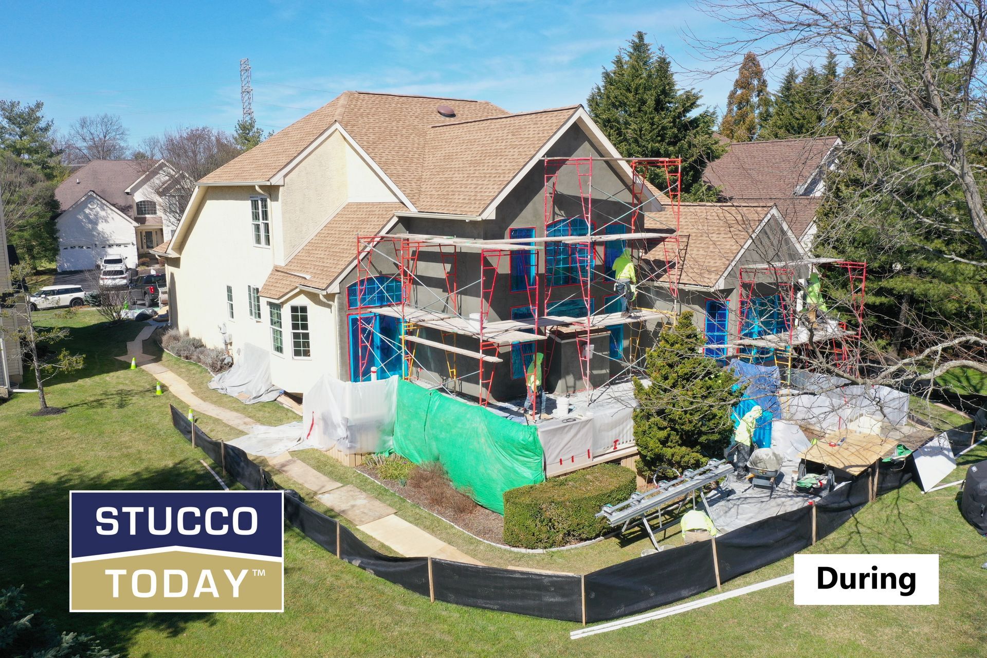 House under construction with scaffolding; stucco application during renovation.