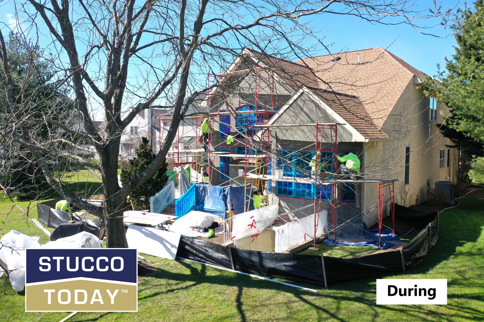House under construction with scaffolding and protective barriers.