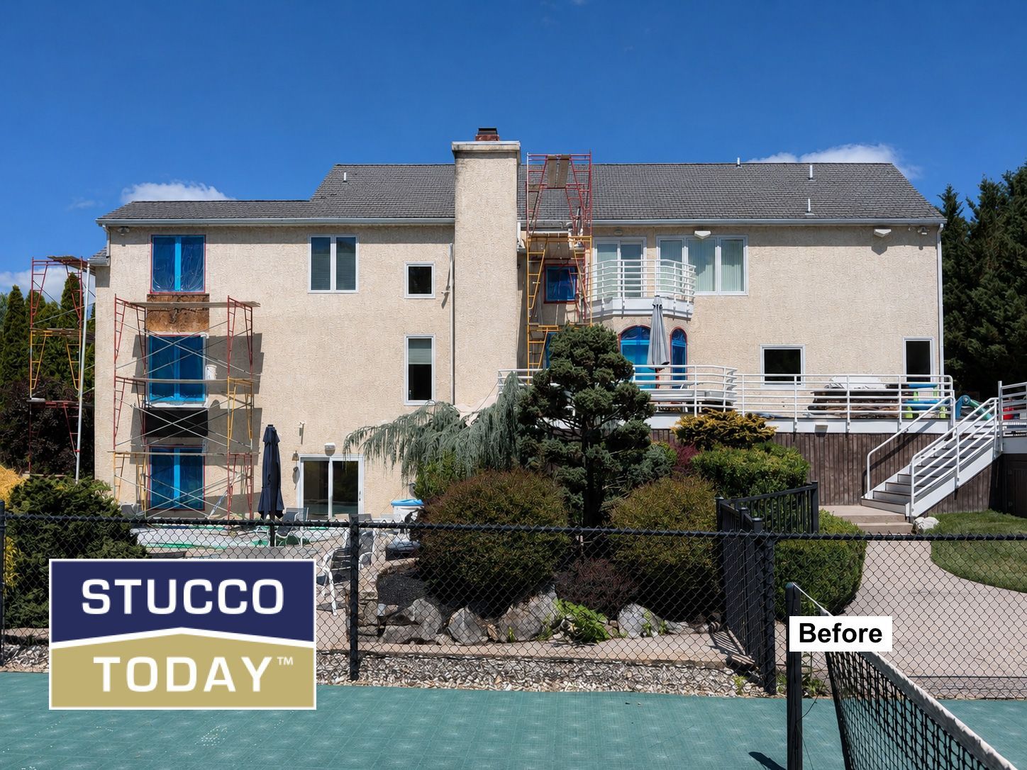 Before view of a two-story stucco house exterior with blue trim and balcony railings.