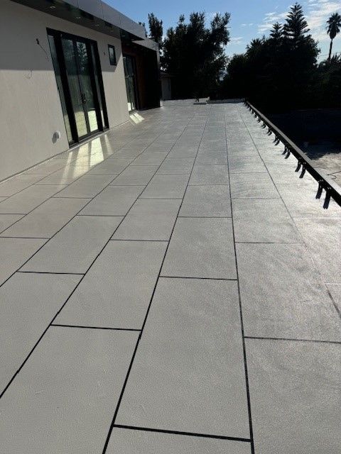 Waterproofed deck with large tiles, sealed to prevent water damage.