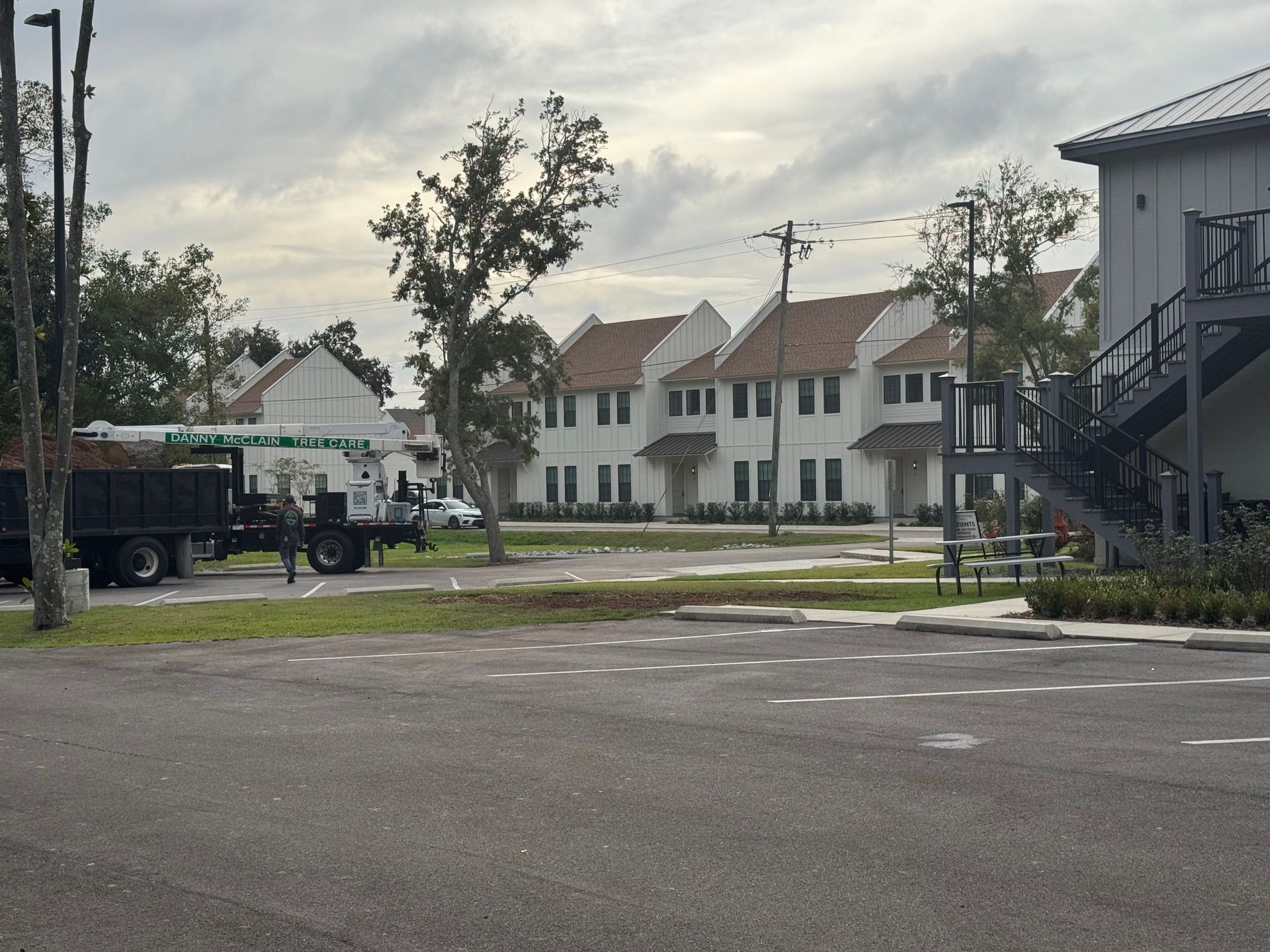 Buildings with white exteriors and brown roofs, with a truck on a gray road.