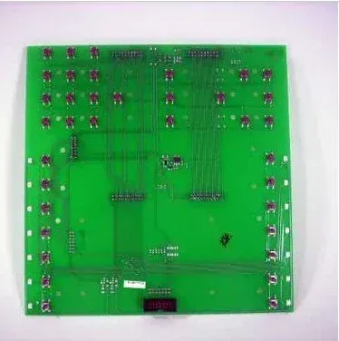 Green circuit board with rows of components and connectors on a white background