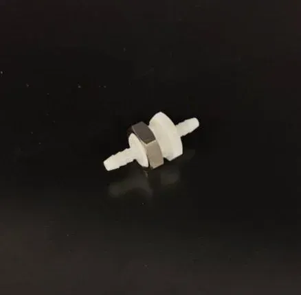 Small white mechanical component with threaded ends on a black background