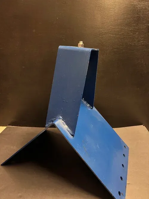 Blue metal bracket on a brown surface, shown at an angle.