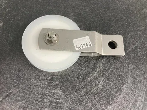 White wheel on a metal bracket with a small label, resting on a gray surface