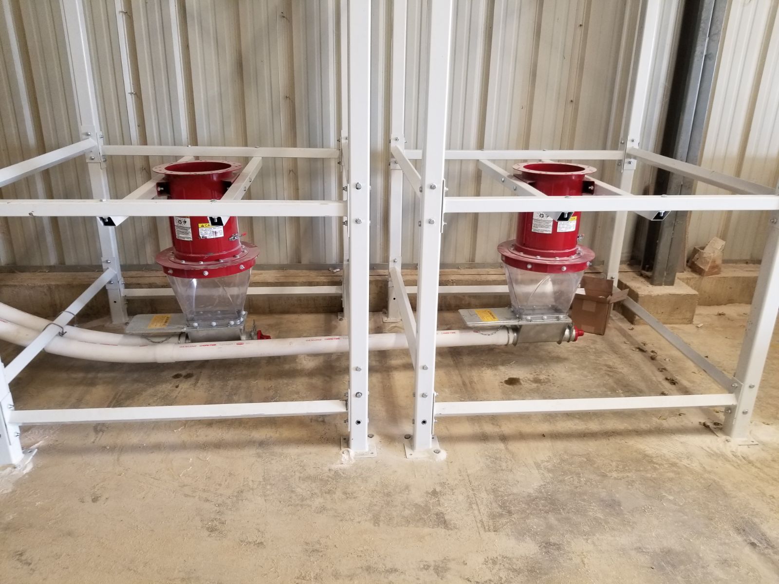 Two red industrial valves behind a white metal safety railing in a utility room