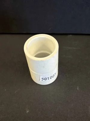 Small white cylindrical plastic container with an open top, resting on a dark surface.