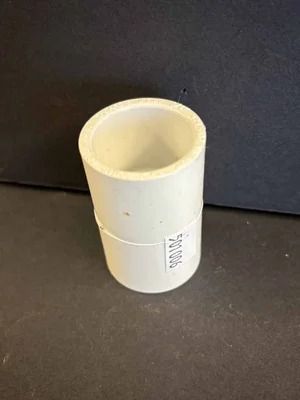 White plastic cylindrical cup or pipe fitting on a dark background