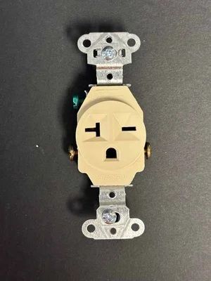 Wall outlet with a beige faceplate and black tape forming a simple face