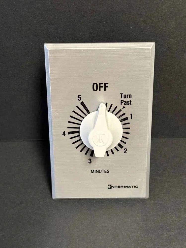 White wall timer switch with OFF label and minute dial on a gray plate
