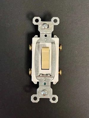 White wall light switch on a dark background