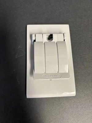 White triple light switch on a dark wall plate, centered on a dark background